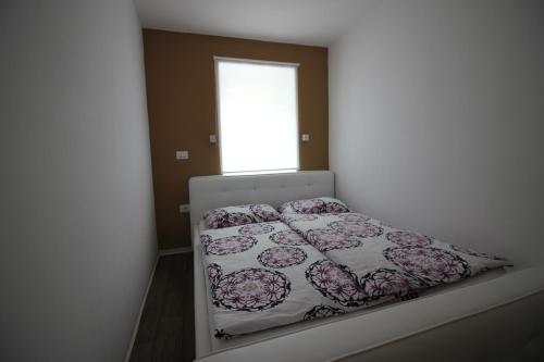 a bedroom with a bed in a room with a window at Apartments Pri Jakobu in Kobarid