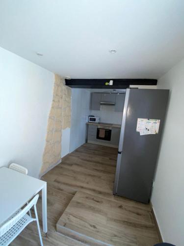 une petite cuisine avec un réfrigérateur et une table dans l'établissement Charmante maison atypique ambiance ville village, à Deuil-la-Barre