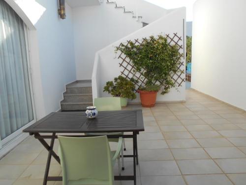 a dining room with a table and green chairs at Garifalia Studios in Kalamaki Heraklion