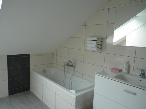 a white bathroom with a tub and a sink at Logis Hôtel Notre-Dame - restaurant ouvert midi et soir sauf dimanche soir in Danne-et-Quatre-Vents
