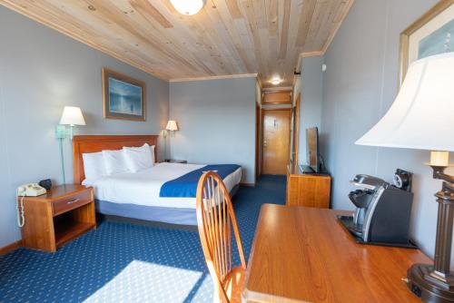 a hotel room with a bed and a desk and a table at Fisherman's Wharf Inn in Boothbay Harbor