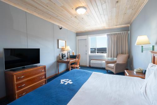 a hotel room with a bed and a flat screen tv at Fisherman's Wharf Inn in Boothbay Harbor