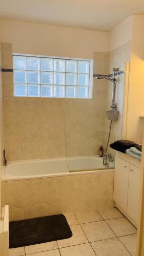 La salle de bains est pourvue d'une baignoire et d'une fenêtre. dans l'établissement Appartement 2 personnes sur Amiens, à Amiens