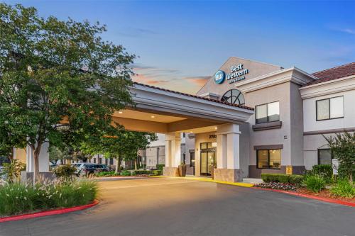 a hotel building with a parking lot in front of it at Best Western Valencia/Six Flags Inn & Suites in Santa Clarita