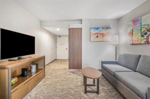 a living room with a couch and a flat screen tv at Best Western Valencia/Six Flags Inn & Suites in Santa Clarita