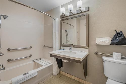 a bathroom with a sink and a tub and a toilet at Best Western Valencia/Six Flags Inn & Suites in Santa Clarita