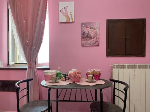 Giulieda in Magicland في نابولي: طاولة صغيرة مع كرسيين وجدار وردي