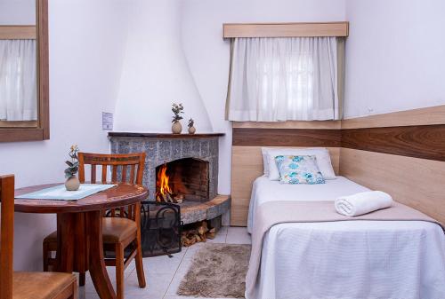 a room with two beds and a fireplace at Pousada das Videiras boutique in Monte Verde