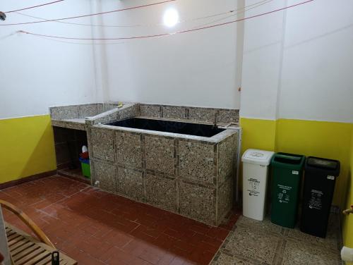 a bathroom with a sink and two trash cans at Glamar suits in Arboletes