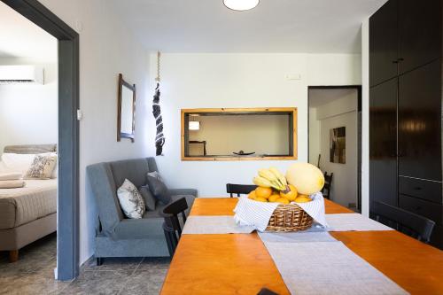 Sala de estar con mesa y cesta de fruta en Pelekanos Beachfront Apartment, en episkopi-chania