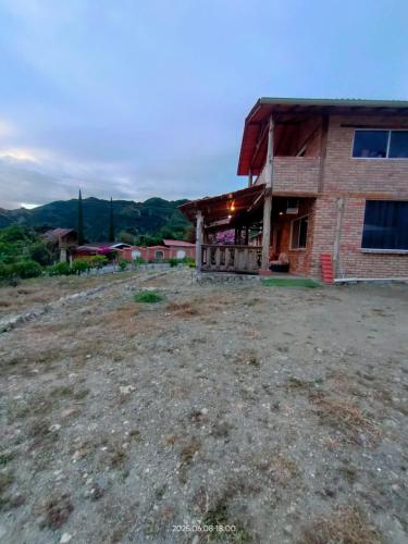 a house on top of a hill with a yard at Acogedora Casa de Campo Vilcabamba in Loja