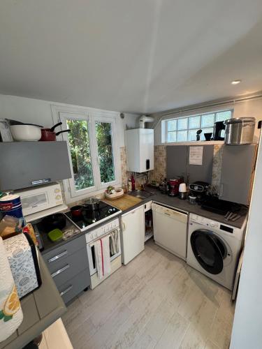 une cuisine avec un évier et une cuisinière four supérieur dans l'établissement Maison calme bord de mer 150m, à Saint-Lunaire