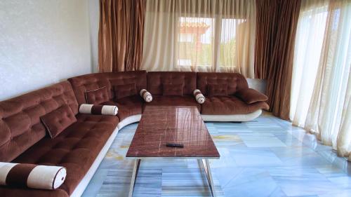 a living room with a brown couch and a table at CASA DEL TITO in Oulad Akkou