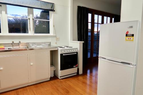 オークランドにある3 Bedroom House Aのキッチン(白い家電製品、白い冷蔵庫付)