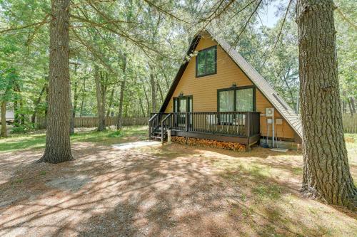 a cabin in the woods with a tree at Walk to Fox Lake Pet-Friendly A-Frame with Fire Pit in Twin Lake