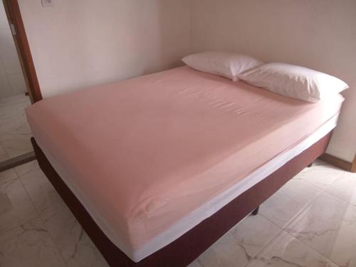 a bed with white sheets and pillows on it at Casa em Lavras Novas - 2 Suítes casal - AP02 in Ouro Preto