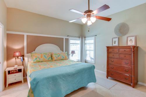 a bedroom with a bed with a ceiling fan and a dresser at 5 Mi to Fort Myers Beach Home with Heated Pool! in Fort Myers