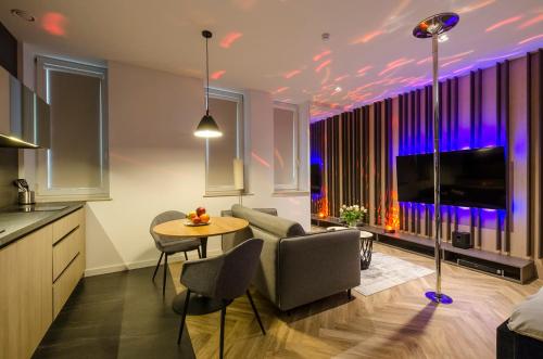 a kitchen and living room with a couch and a table at LupoApartments z Klimatyzacją do wyboru z Jacuzzi Pole Dance Parking Dostęp na Kod in Łódź
