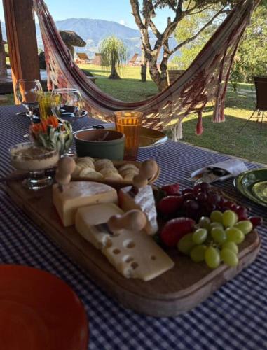 a tray of cheese and fruit on a table at Chácara da Mantiqueira - São Francisco Xavier in São José dos Campos