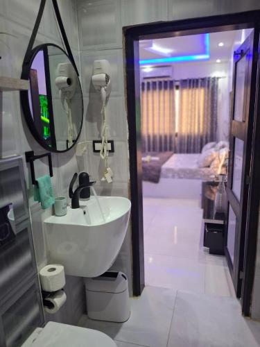un bagno con lavandino e specchio di Seckebe Immo STUDIO JAUNE a Dakar