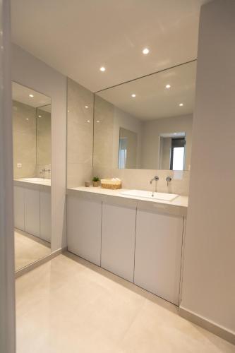 a bathroom with two sinks and a large mirror at Laconian Blue Residence in Gythio