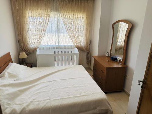 a bedroom with a bed and a mirror and a window at VACANCE a MAHDIA in Bin Rhilouf