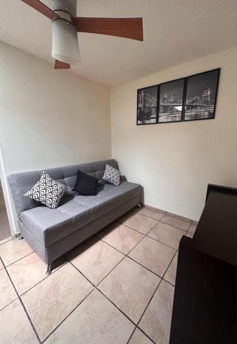 a living room with a couch and a ceiling fan at Casa en coto privado cerca de de la central nueva in Guadalajara