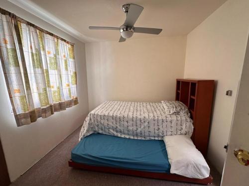 a bedroom with a bed and a ceiling fan at Casa en coto privado cerca de de la central nueva in Guadalajara