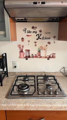 a stove top in a kitchen with a sign on the wall at Casa en coto privado cerca de de la central nueva in Guadalajara