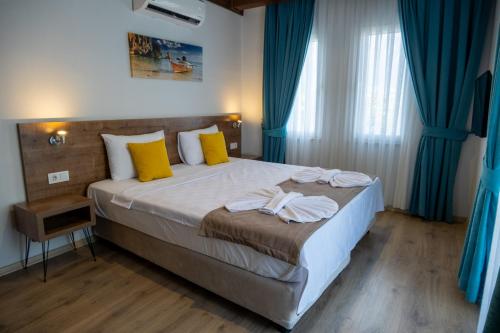 a bedroom with a large bed with blue curtains at Güneş Boutique Hotel - Oludeniz in Oludeniz