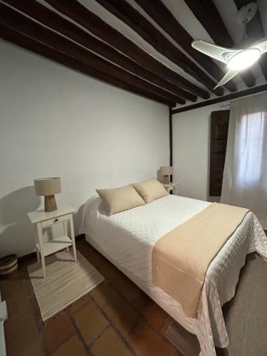 a bedroom with a large bed and a white wall at Casa Alba in Alcalá de Henares