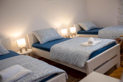 a bedroom with three beds with towels on them at Lumaris in Ogulin