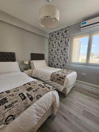 una camera d'albergo con due letti e una finestra di Departamento Santa Fe a Salta