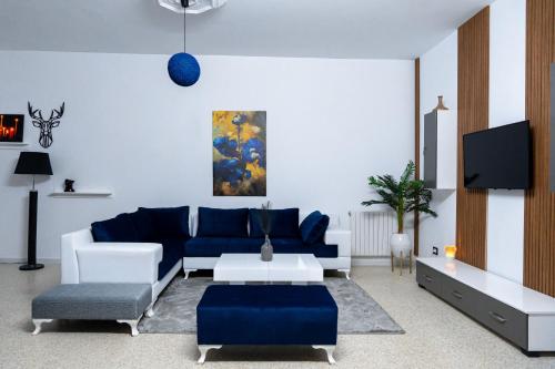 a living room with a blue couch and a tv at CASABLU Apparte - Terrasse avec vue Sunset in Nabeul
