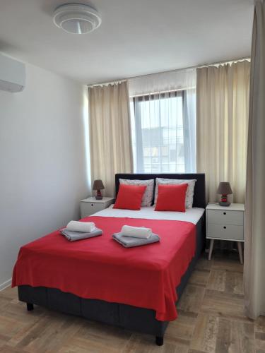 a bedroom with a large bed with red pillows at Ela, Kedar 7 in Sveti Vlas