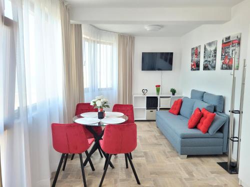 a living room with a table and red chairs at Ela, Kedar 7 in Sveti Vlas