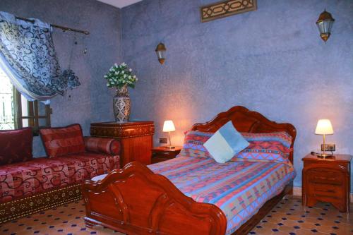 ein Schlafzimmer mit einem Bett und einer Couch in der Unterkunft Magnifica Casa cerca de Marrakech con gran piscina totalmente privada in Tahannaout