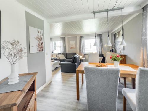 a dining room and living room with a table and chairs at Strandwind in Dannau