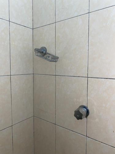 a tiled shower with a toilet paper dispenser at Hotel Sabrina in Cedro