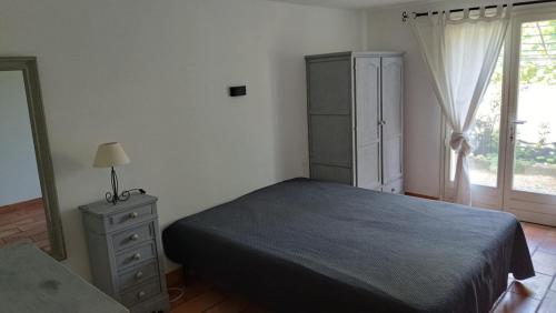 a bedroom with a bed and a dresser and a window at Bastide la Bohême in La Ciotat