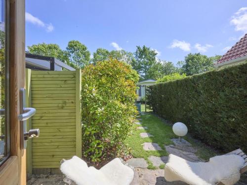 a garden with a hedge and a fence at Tiny House Jet in Goedereede