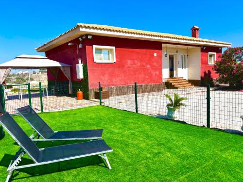 a yard with a chair in front of a house at --CHALET EN ALICANTE-- Piscina Privada in Moralet