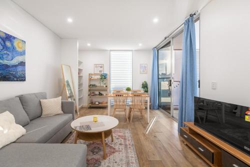 a living room with a couch and a tv at Stylish Comfort 1BR Apt w free P in Sydney