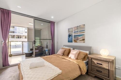 a bedroom with a large bed and a large window at Stylish Comfort 1BR Apt w free P in Sydney