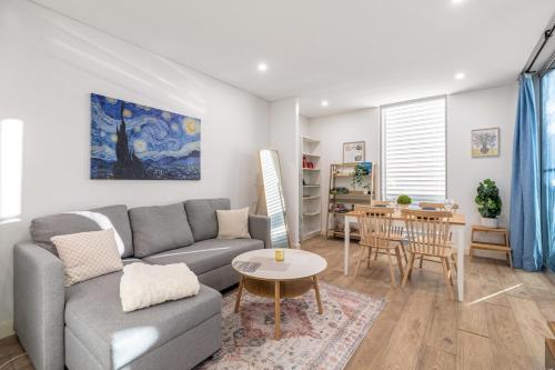 a living room with a couch and a table at Stylish Comfort 1BR Apt w free P in Sydney