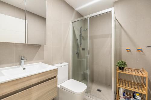 a bathroom with a shower and a toilet and a sink at Stylish Comfort 1BR Apt w free P in Sydney