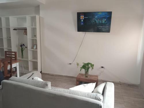a living room with two couches and a tv on the wall at Departamento Nuevo Horizonte Pet Friendly in Olavarría