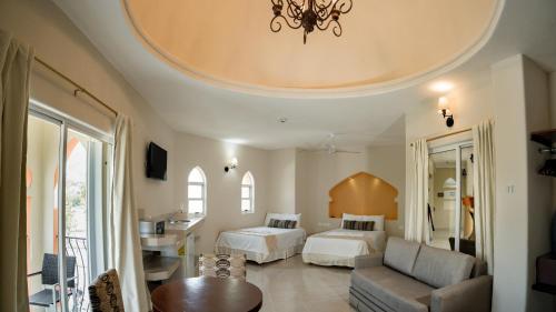 a bedroom with two beds and a living room with a couch at Gran SAHARA in Playa del Carmen