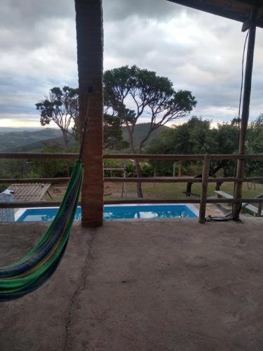 a hammock next to a pool with a fence at Sítio topo do Vale in Sabará