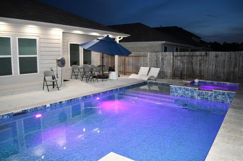 a swimming pool with a table and an umbrella at Relitorin Sweet Home & Pool in Spring